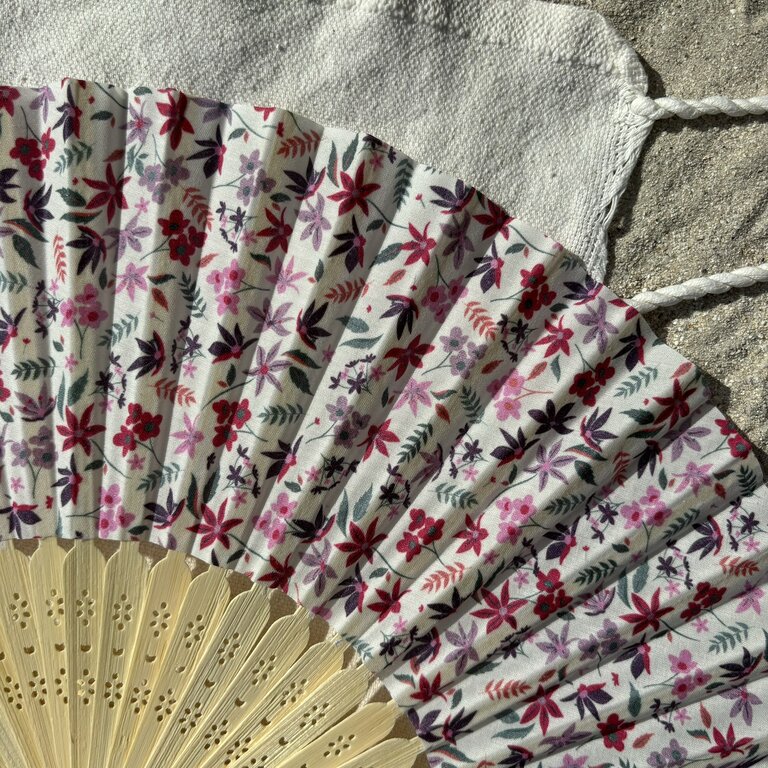 Détail des motifs floraux violets et roses sur tissu Éventail original motifs fleurs violettes et roses en tissu avec structure en bambou – détail du tissu