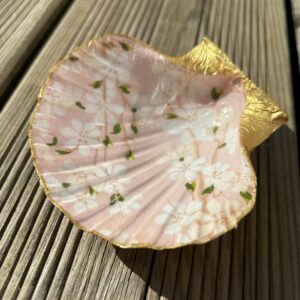 Repose bijoux en coquille St Jacques fleurs blanches fond rose