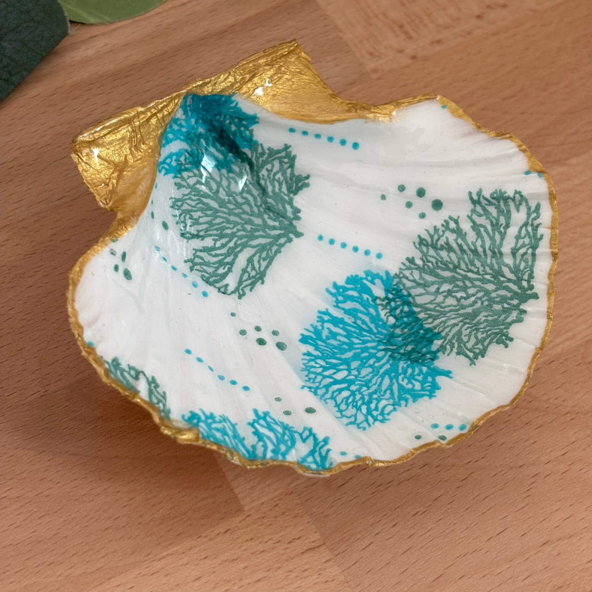 Vue inclinée Repose bijoux original coquillage corail turquoise vu légèrement de côté.