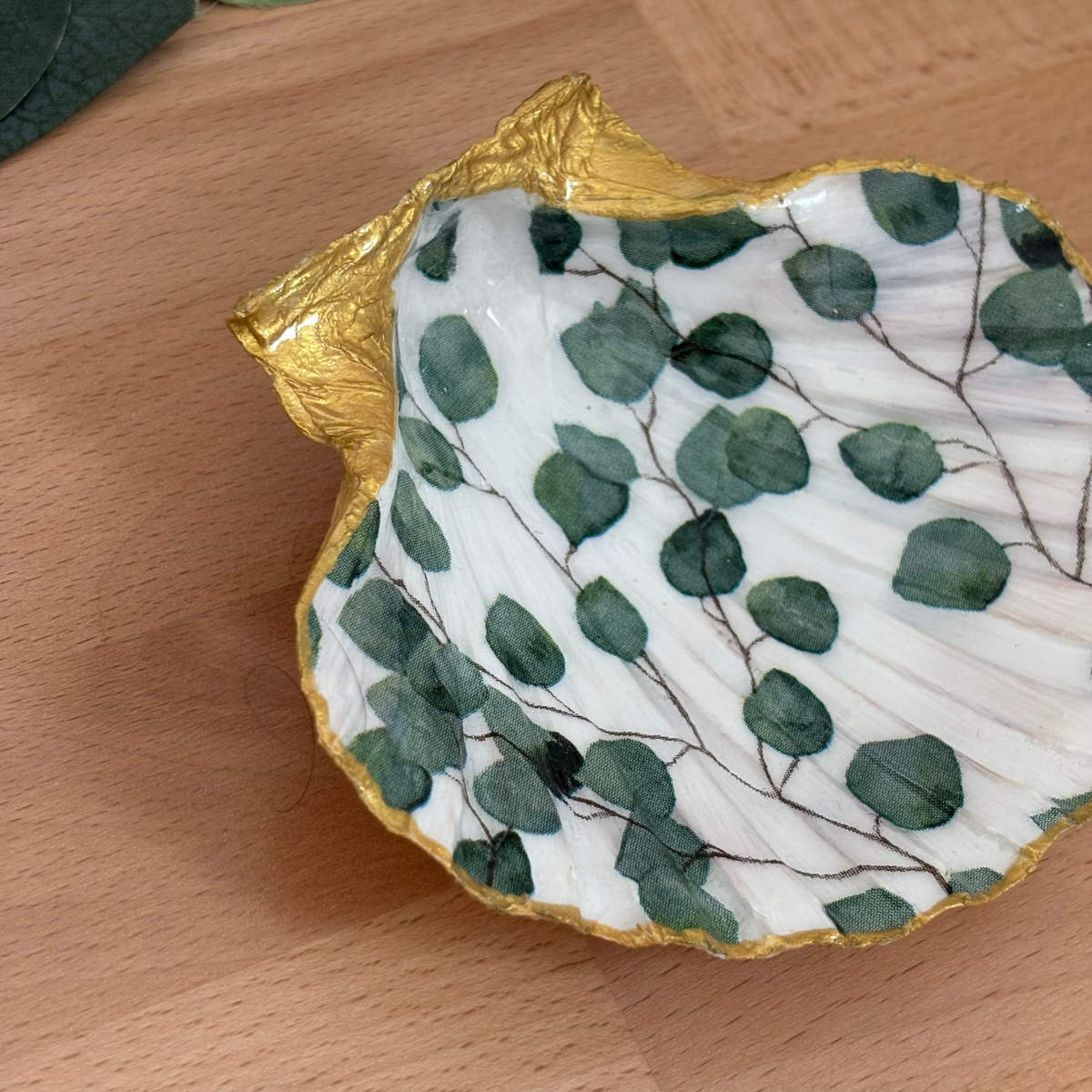 Détail bordure Détail du repose bijoux original coquillage eucalyptus vert sauge avec finition dorée.