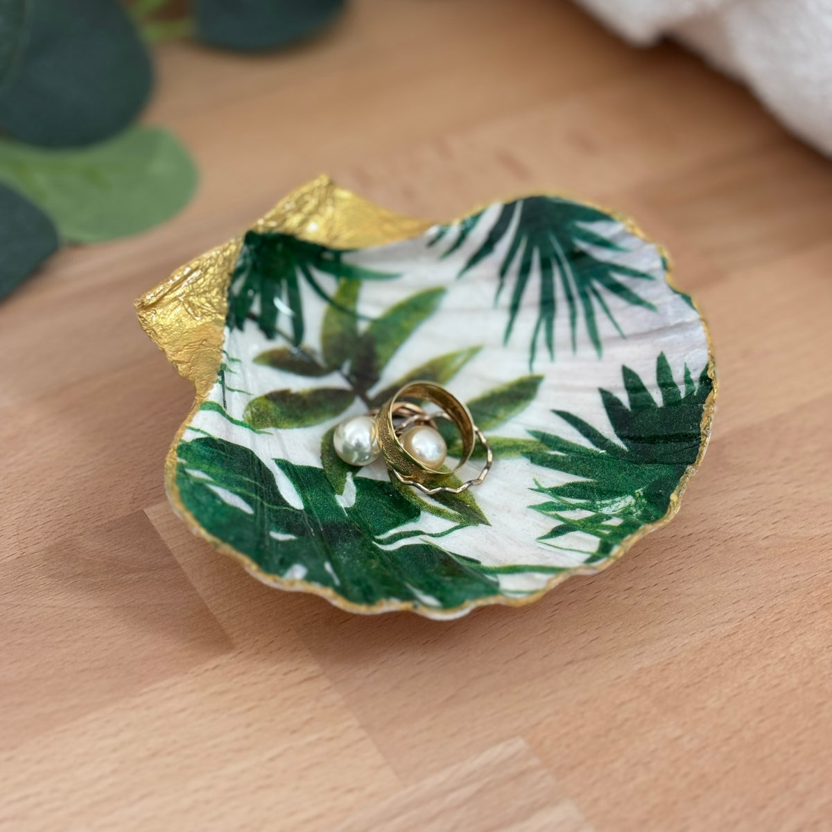 Présentation avec bijoux Repose bijoux original coquillage feuillage tropical vert avec bagues posées à l’intérieur.