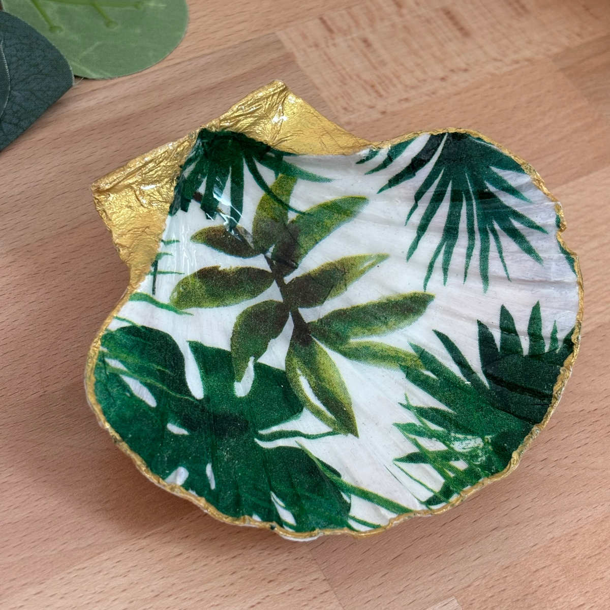 Vue du dessus Repose bijoux original coquillage feuillage tropical vert vu du dessus.