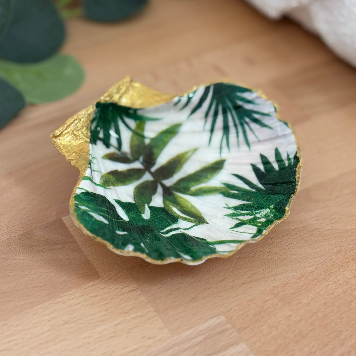 Vue principale Repose bijoux original coquillage feuillage tropical vert vu de face sur support bois.