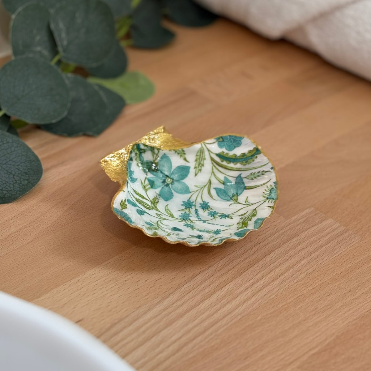 Mise en ambiance Repose bijoux original coquillage fleurs bleu canard en décoration sur meuble bois.