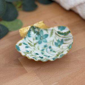 Repose bijoux original coquillage fleurs bleu canard vu de face sur support bois.