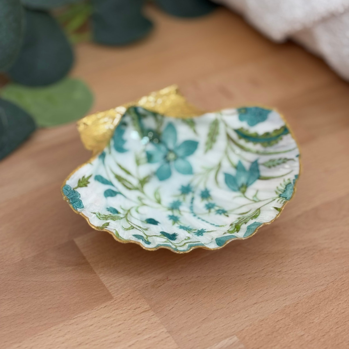 Vue principale Repose bijoux original coquillage fleurs bleu canard vu de face sur support bois.