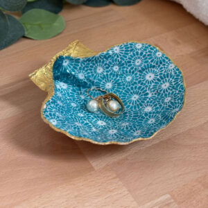 Repose bijoux original coquillage fleurs turquoise avec bagues et boucle d’oreille posées dedans.