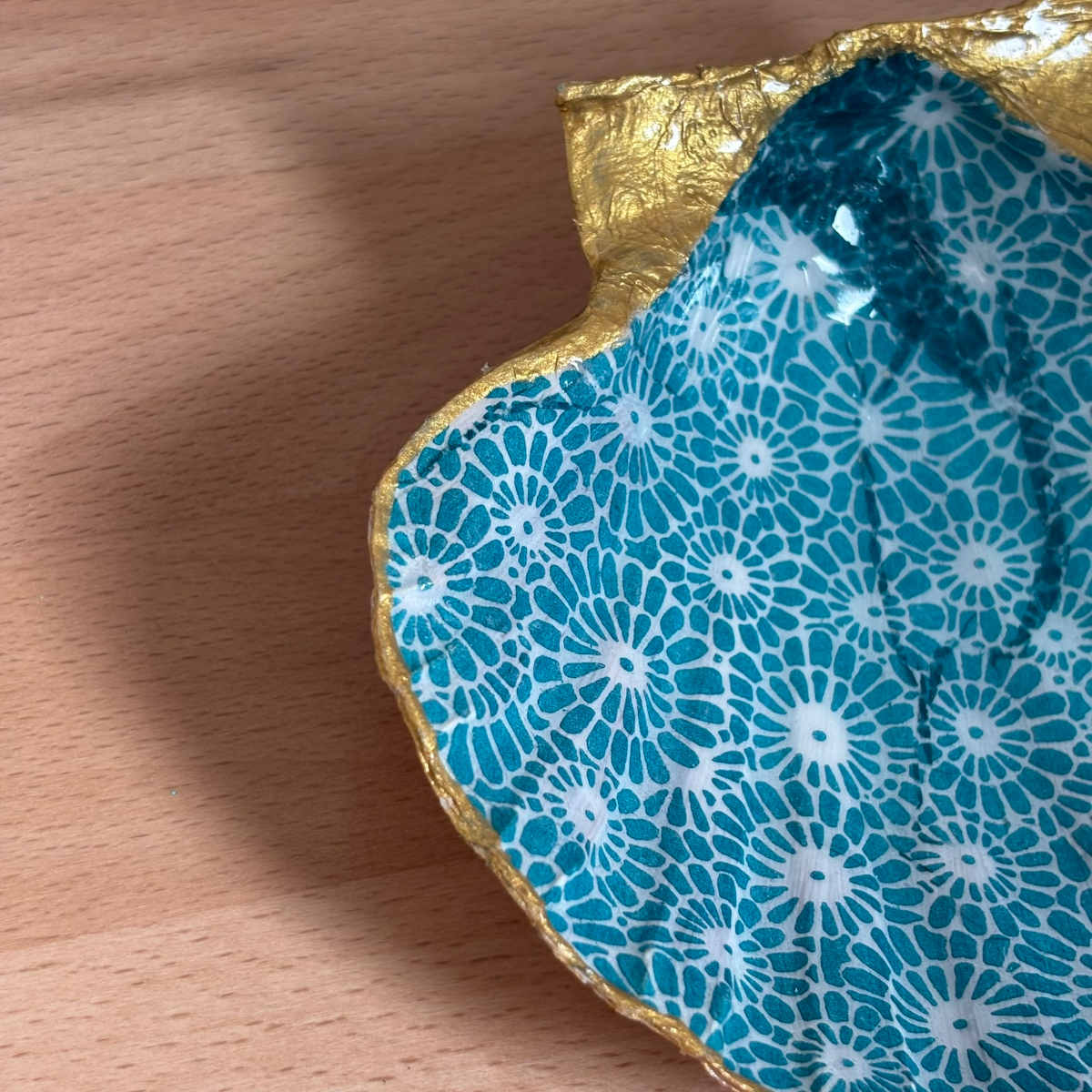 Détail gauche Détail du repose bijoux original coquillage fleurs turquoise avec bordure dorée.