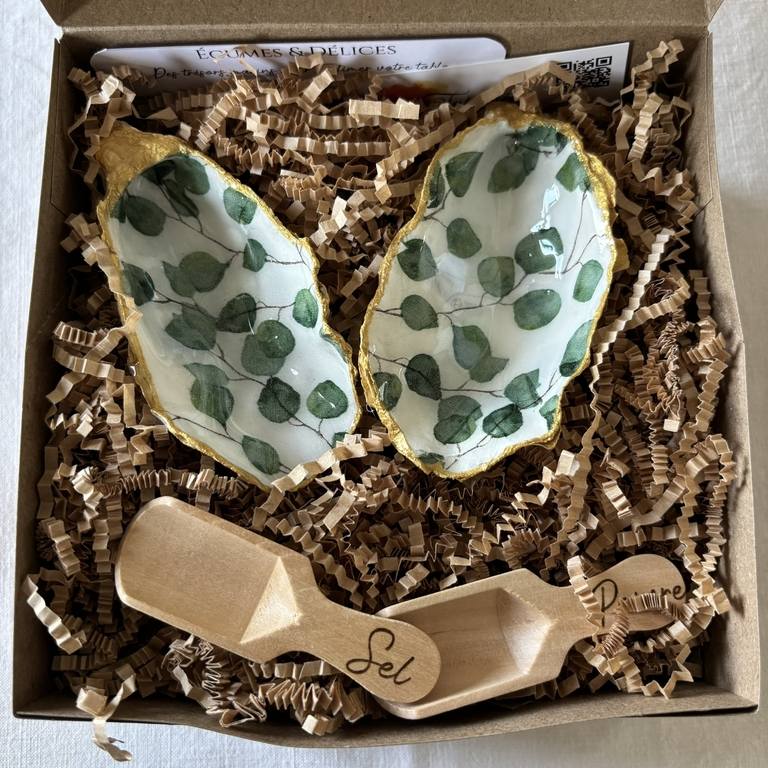 Contenu du coffret – duo sel et poivre motif eucalyptus Coffret ouvert avec deux coquilles décorées de feuilles d’eucalyptus et cuillères en bois gravées