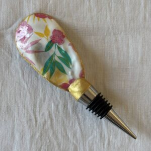 ouchon de vin original motif floral exotique en coquille d’huître, décoré à la main, sur fond clair.