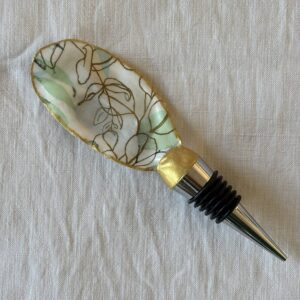 Bouchon de vin original motif feuilles dorées et vert d’eau sur fond clair, création artisanale en coquille d’huître.