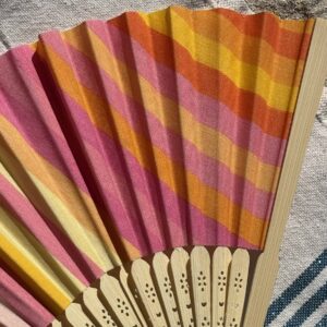 Détail du tissu à rayures multicolores d’un éventail original en bambou