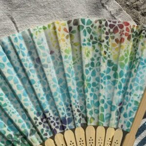 Détail du tissu arc-en-ciel à motifs floraux d’un éventail original