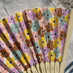 Détail du tissu fleuri pastel d’un éventail original en bambou