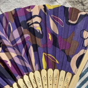 Détail du tissu violet à motifs floraux d’un éventail original en bambou