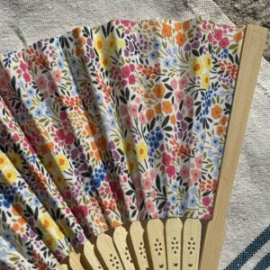 Détail du tissu fleuri multicolore d’un éventail original en bambou