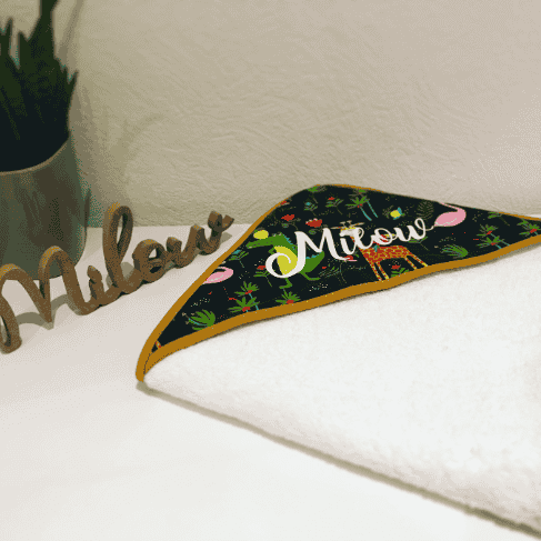 Cape de bain personnalisée – modèle Milow Cape de bain bébé personnalisée avec prénom Milow, tissu jungle noir et biais moutarde