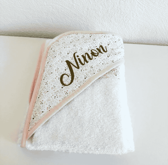 Cape de bain personnalisée – modèle Ninon Cape de bain bébé personnalisée avec prénom Ninon, tissu fleuri doré et biais rose poudré