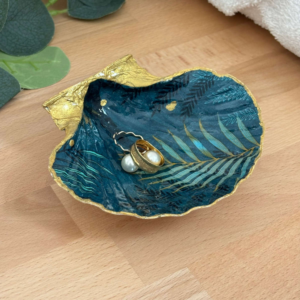 Présentation avec bijoux Repose bijoux original coquillage bleu nuit doré avec bagues et boucles d’oreilles.