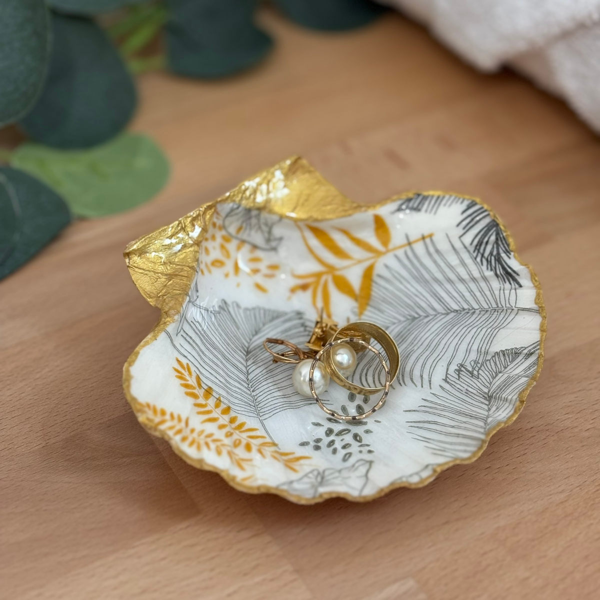 Présentation avec bijoux Repose bijoux original coquillage feuillage doré avec bagues et boucles d’oreilles.