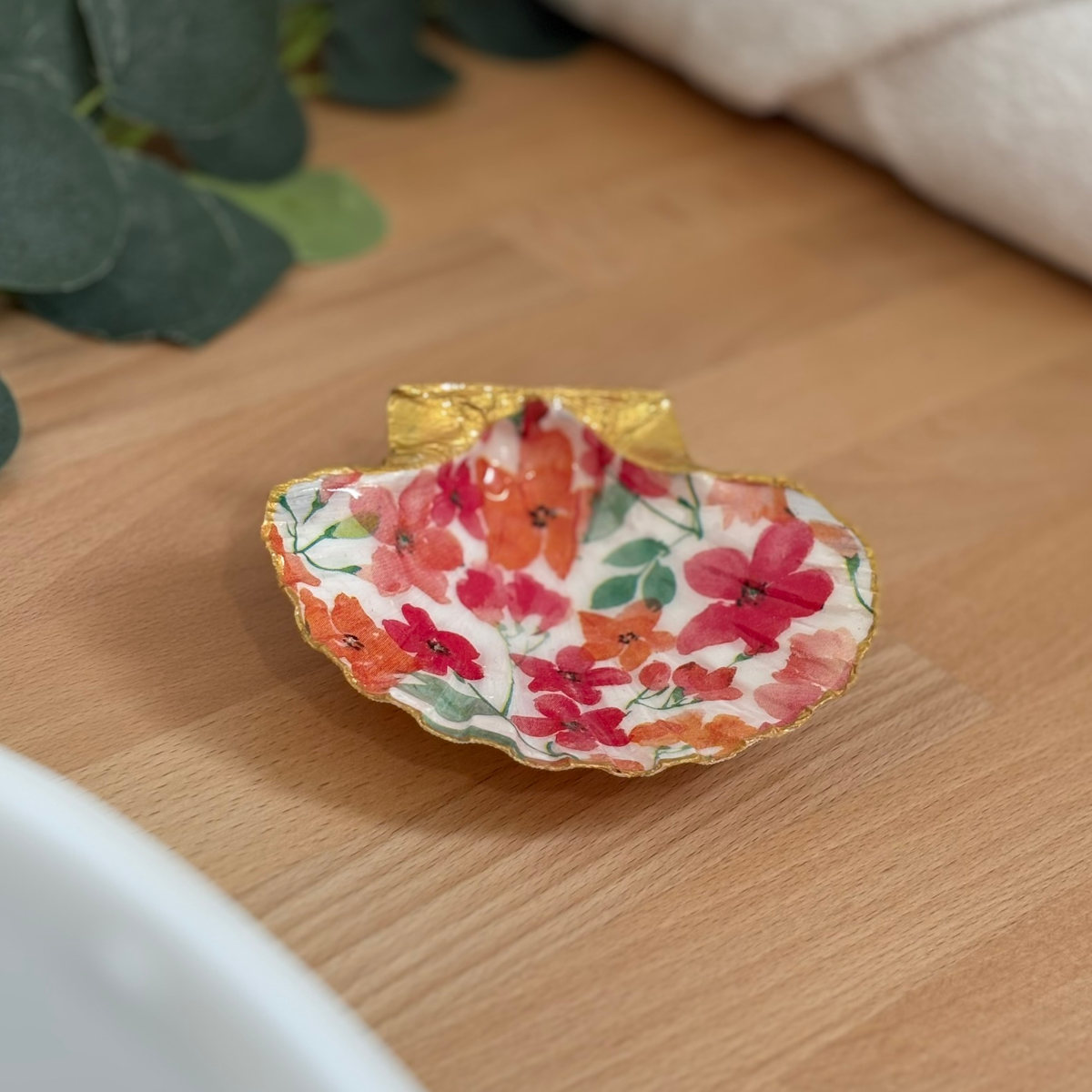 Mise en ambiance Repose bijoux original coquillage fleurs corail orange en décoration sur meuble bois.