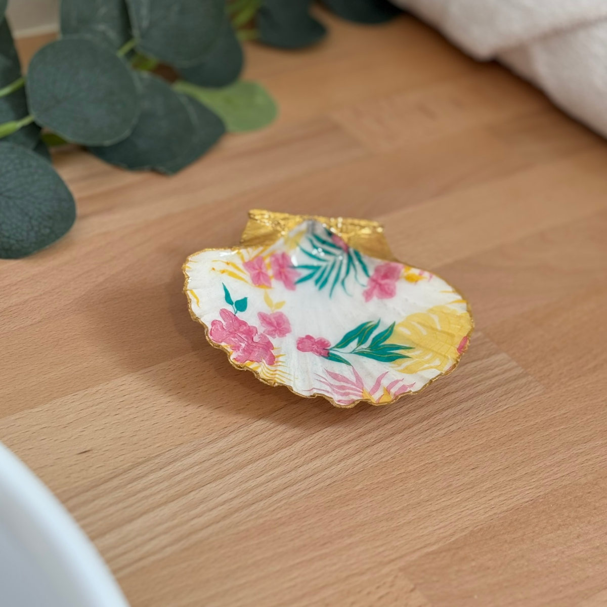 Mise en ambiance Repose bijoux original coquillage fleurs tropicales en décoration sur meuble bois.