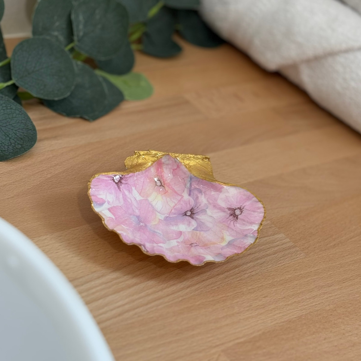 Mise en ambiance Repose bijoux original coquillage hortensias roses en décoration sur meuble bois.
