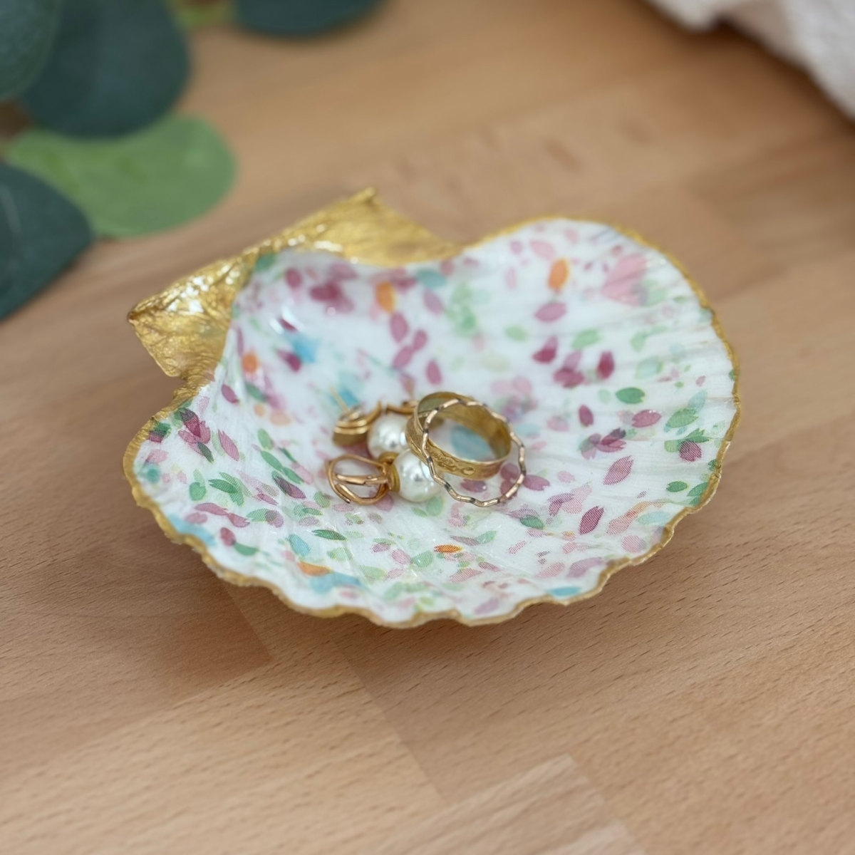 Présentation avec bijoux Repose bijoux original coquillage pétales pastel avec bagues et boucles d’oreilles.