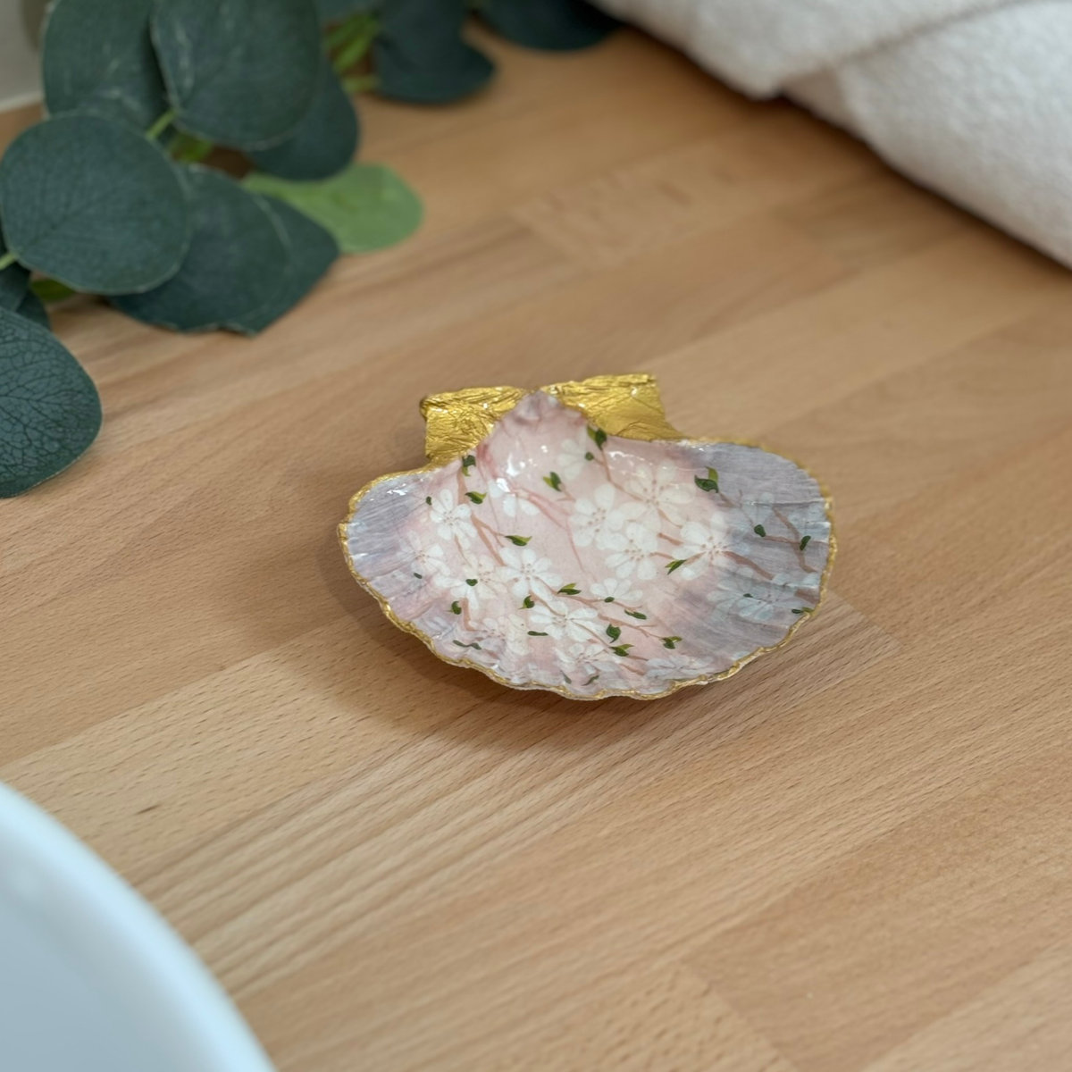 Mise en ambiance Repose bijoux original coquillage rose poudré en décoration sur meuble bois.