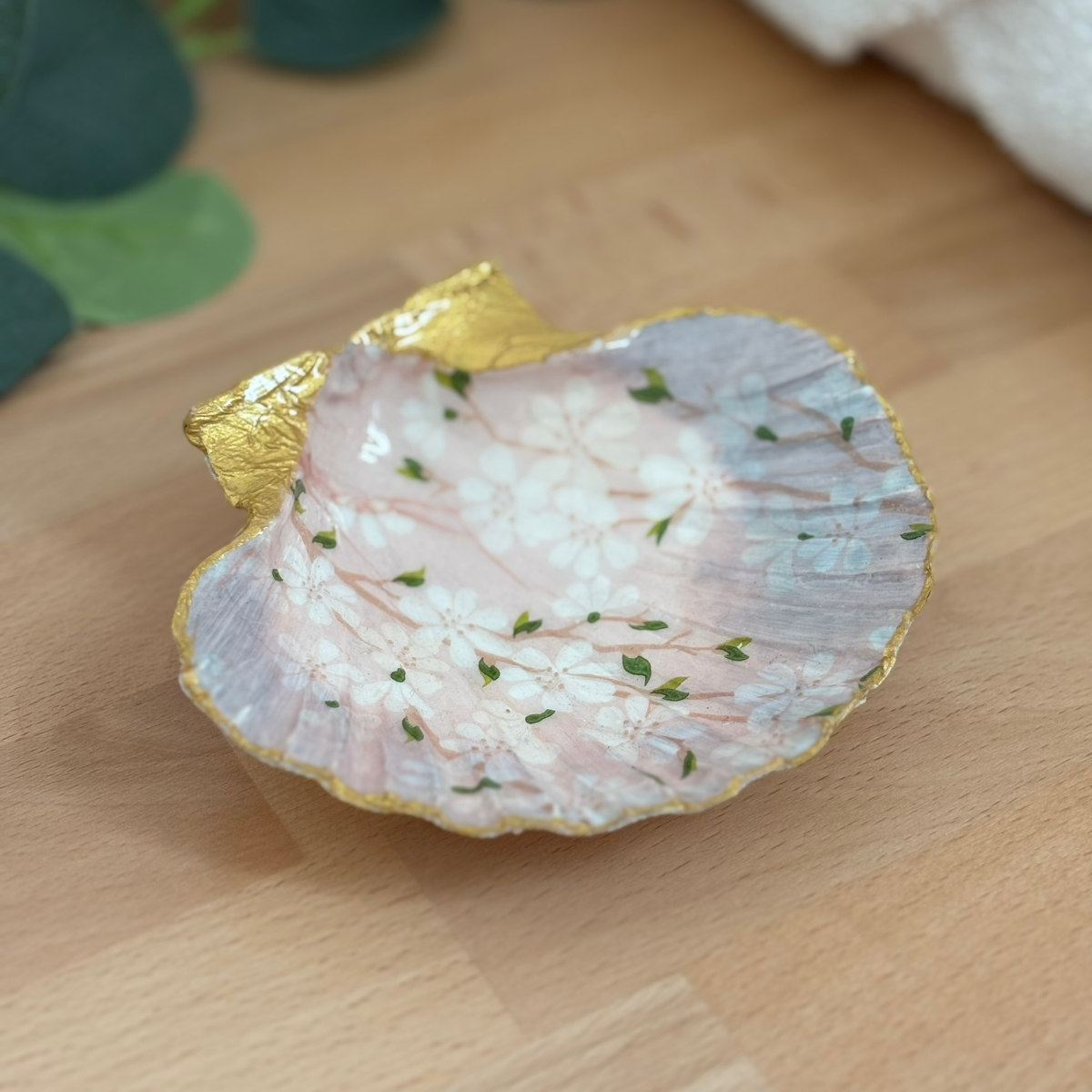 Vue principale Repose bijoux original coquillage rose poudré vu de face sur support bois.